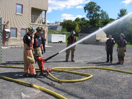 firemen spraying a fire hose