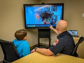Fireman teaching yur boy about danger of fires.